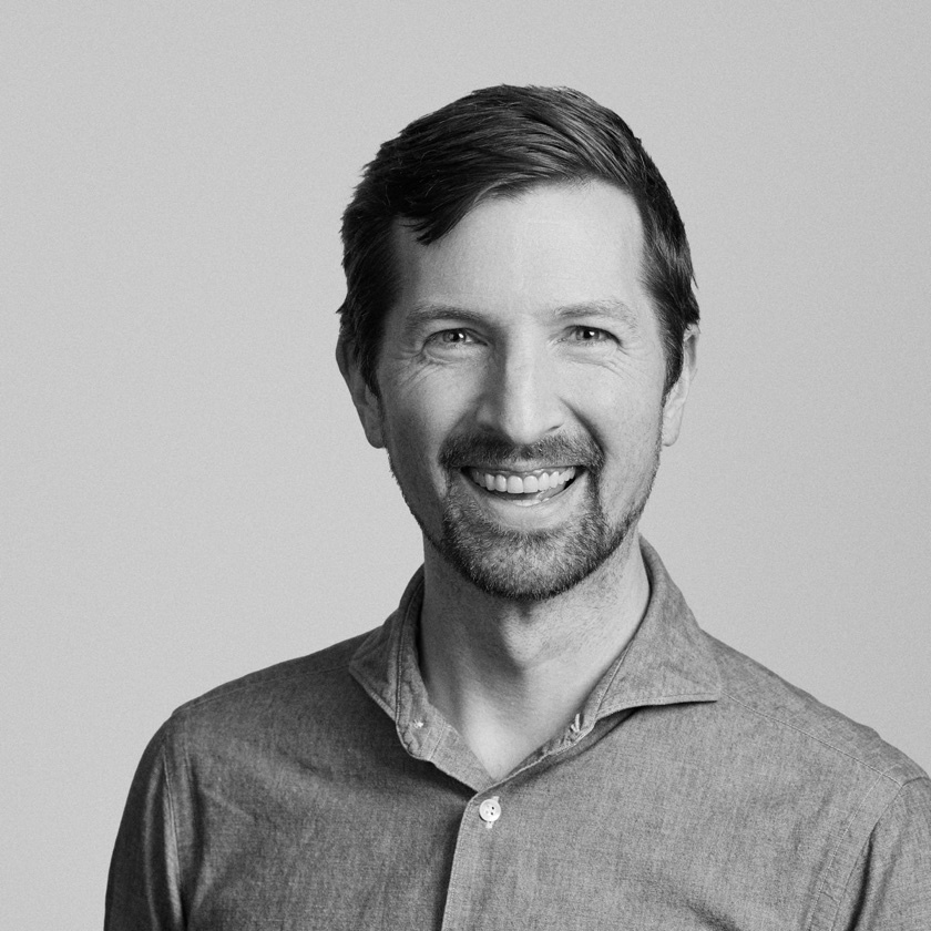 Ollie Happy, smiling, in a black and white portrait